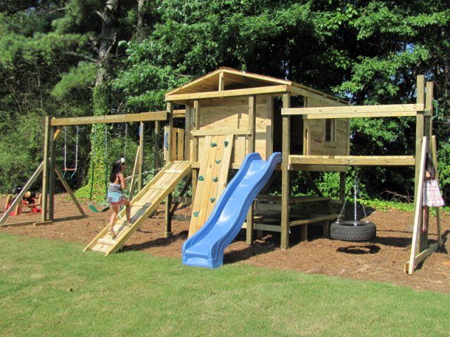 8x8 model as shown $4925.00 including Swings, Trapeze Bar with Rings, Wooden Ramp with Rope, Wooden Bridge with Tire Swing, rock Climbing Wall, Monkey Bars, and Picnic Table