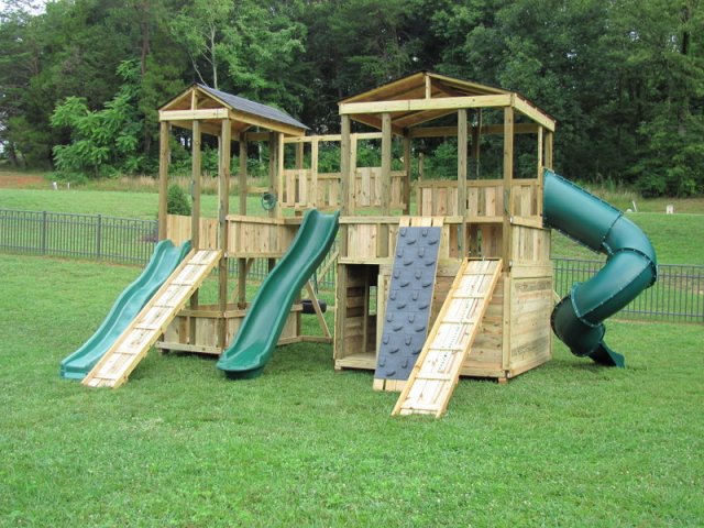 8x8 Mammoth and 4x8 Fox's Den models as shown $9195 including 10' Wave Slide, 13' Wave Slide, Enclosed Turbo Slide, Shingled Roofs, Rock Climbing Wall, Soft Grip Swings, Wooden Ramps with Rope, Wooden Bridge