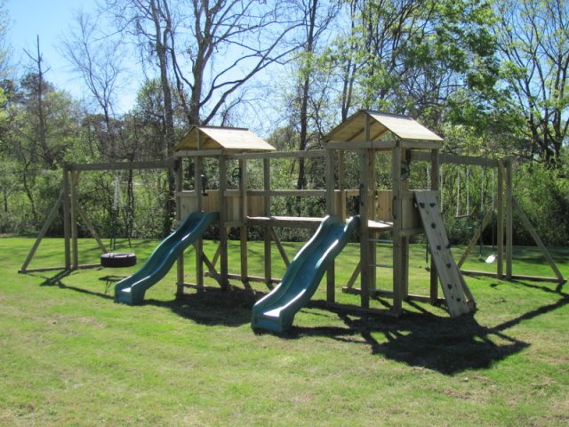 2 4x4 Jungle House models as shown $3050.00 including Wooden Roofs, 2 Slides, Rock Climbing Wall, Soft Grip Tire Swing, Soft Grip Swings, Trapeze Bar with Rings, Periscope, and Wooden Bridge